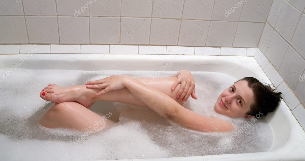 Мокрая девица с крупной грудью позирует в ванной